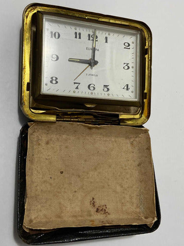 Vintage German Europa travel clock with 2 jewels in a worn protective case, classic square design and gold trim.