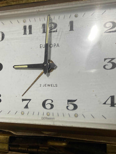 Close-up of vintage Europa Germany clock face with 2 jewels and classic black hands showing time at 9:00:02