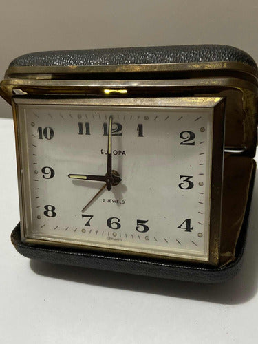 Vintage German Europa travel clock with 2 jewels, folded black leather case and gold-tone frame showing time at 12 o’clock