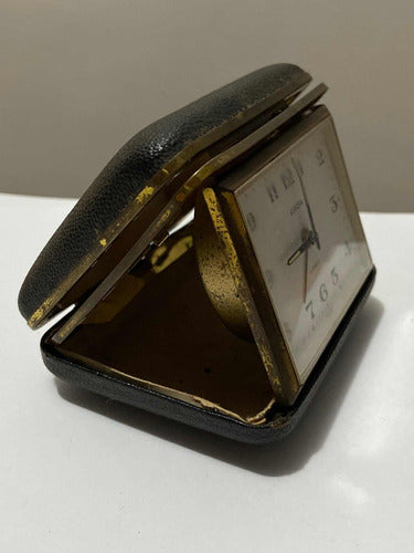 Vintage German travel alarm clock in a protective leather case with white dial and gold-toned frame from Europe
