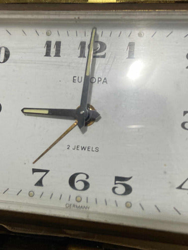 Close-up of vintage German Europa clock face with black hands and 2 jewels mechanism detail
