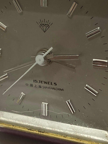 Close-up of vintage Shanghai China 15 jewels watch dial with silver hour markers and hands on beige face