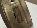 Close-up of the back of a vintage silver alarm clock showing the time adjustment switches.