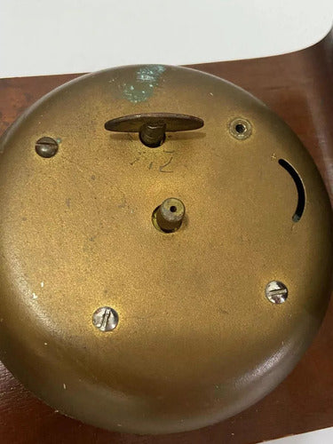 Close-up of vintage brass wind-up mechanism on antique wooden table clock